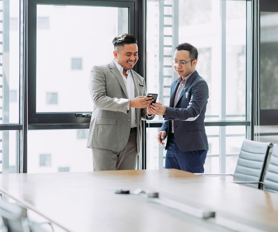 deux hommes se serrant la main dans une salle de conférence